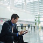Businessman in Airport Making Electronic Notes